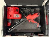 a red cordless drill and a red cordless nailer in a black case