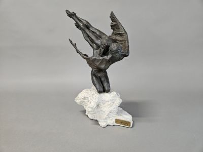bronze sculpture of a man on a rock with a knife in his hand