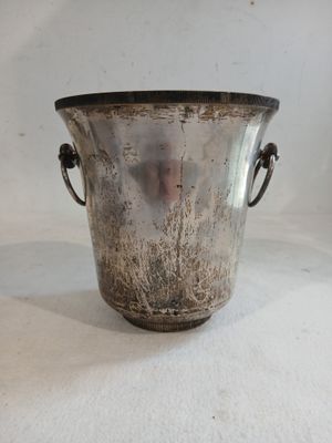 un vase en argent posé sur une surface blanche