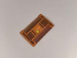 a small wooden comb with a green dot on it