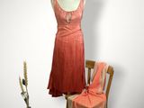 une robe posée sur un pied de mannequin à côté d'une chaise