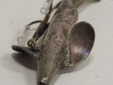 a metal object with a spoon and spoon rest on it