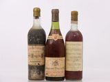 trois bouteilles de vin posées les unes à côté des autres sur une surface blanche