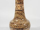 a brown vase that is sitting on a white surface