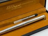 une image représentant un stylo posé dans une boîte sur une table