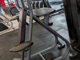 a row of machines in a gym with a red sign on the wall