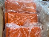 une boîte remplie de morceaux de plastique orange posée par terre
