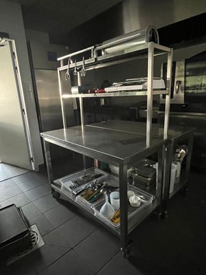 une cuisine avec un plan de travail en inox et une étagère en métal