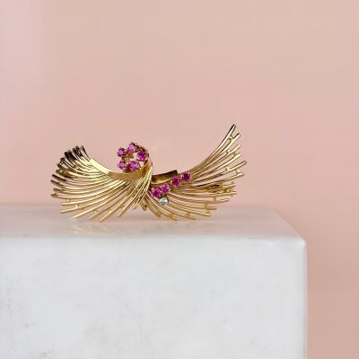 a close up of a gold ring with pink stones on top of a marble block