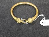 a close up of a gold bracelet with a tag attached to it