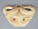 a ceramic sculpture of a woman ' s face on a gray surface