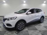 un 4x4 blanc garé sur un sol en damier dans un garage