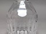 a clear glass bottle with a silver lid on a table