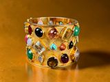 bracelet with multi colored stones on a gold plated surface