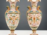 Deux vases sont posés sur une table blanche, sur fond gris.