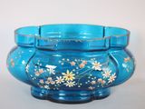 un bol en verre bleu orné de fleurs peintes