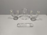 three clear glass candlesticks and a glass tray on a white table
