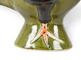 a green vase with a bird on it on a white background