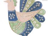 un oiseau bleu et vert posé sur une surface blanche