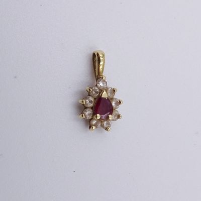 un gros plan d'un pendentif en pierre rouge posé sur une surface blanche