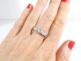 a woman ' s hand with a diamond ring on it