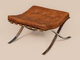 a brown leather chair sitting on top of a metal frame