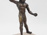 bronze statue of a man holding a tennis racquet on a marble base