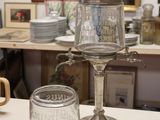 a glass jar sitting on top of a table next to a glass cup