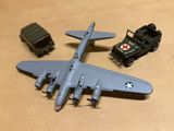 deux véhicules militaires miniatures et un modèle réduit d'avion posés sur une table