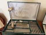 a green case with silverware in it on a table
