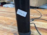 une image représentant une enceinte noire posée sur une table en bois