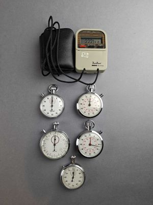 five stopwatchs and a wallet on the table
