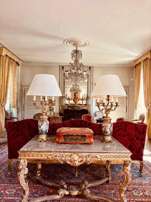 a living room with a table, couches, lamps, and a chandelier