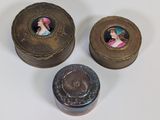 deux petites boîtes en métal sur lesquelles figurent les photos d'une femme et d'un homme