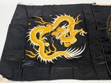 an old black and gold dragon flag with a hat on top of it