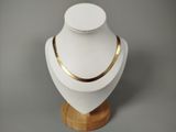 un mannequin blanc portant un collier en or