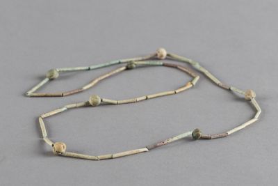 un gros plan d'un collier posé sur une surface grise