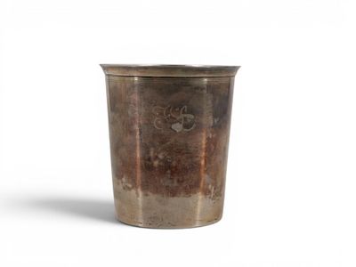 a metal cup that is sitting on a white surface