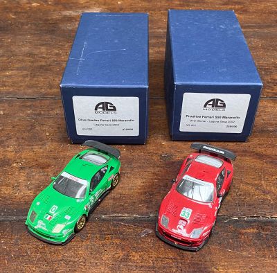 trois voitures jouets assises l'une à côté de l'autre sur une table