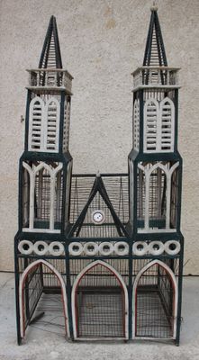 une petite cage à oiseaux surmontée d'une horloge