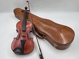 un violon et un étui à violon sur une surface blanche
