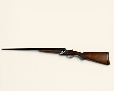 a rifle on a white surface with a white background