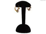 a close up of a pair of earrings on a stand