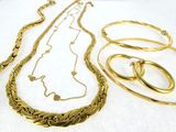beaucoup de colliers et de bracelets en or posés sur une table