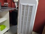 a white air conditioner sitting in the corner of a room
