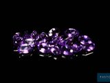 some very pretty purple gems are on a black surface