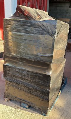 a large stack of books on a pallet in front of a building