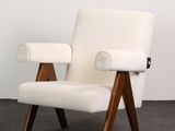 a white chair sitting on top of a carpeted floor next to a white wall