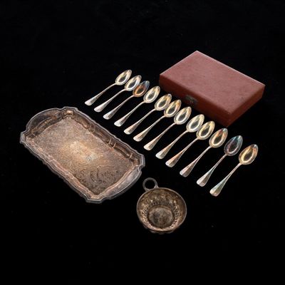 a lot of silver spoons and silverware on a black surface