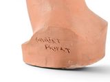 a clay bust of a man with writing on it
